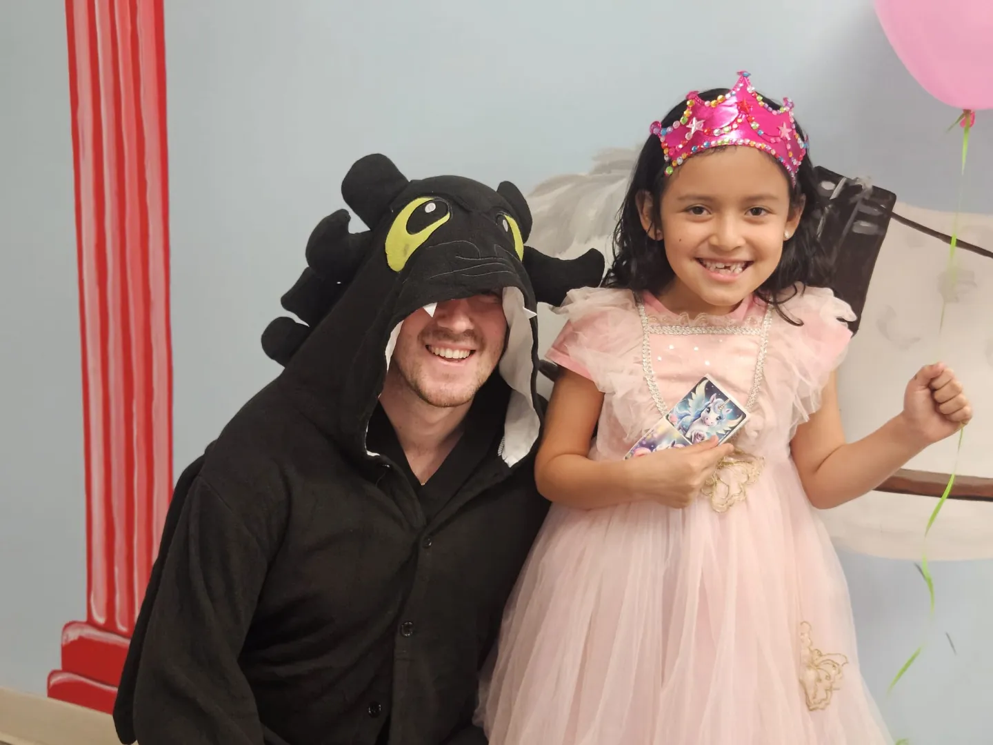 A Dental Care Kids team member in a dragon costume beside a patient dressed as a princess
