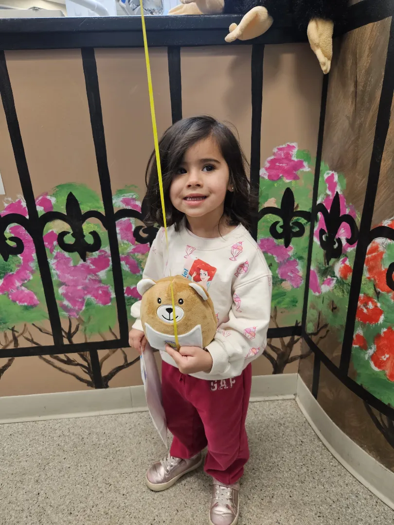 A Dental Care Kids patient holding her stuffed animal in the treatment room