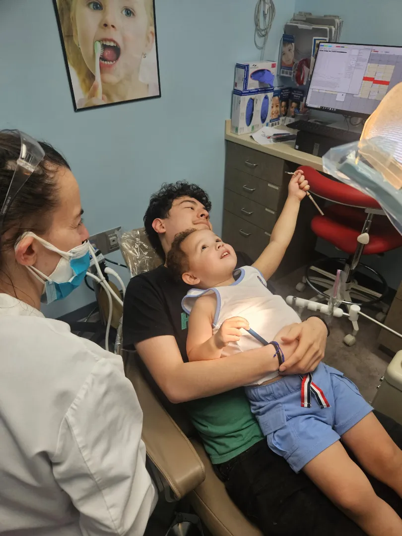 A Dental Care Kids dentist with a parent and toddler settling into the treatment room