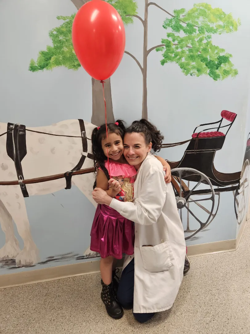 Two Dental Care Kids patients hugging in the mural hallway