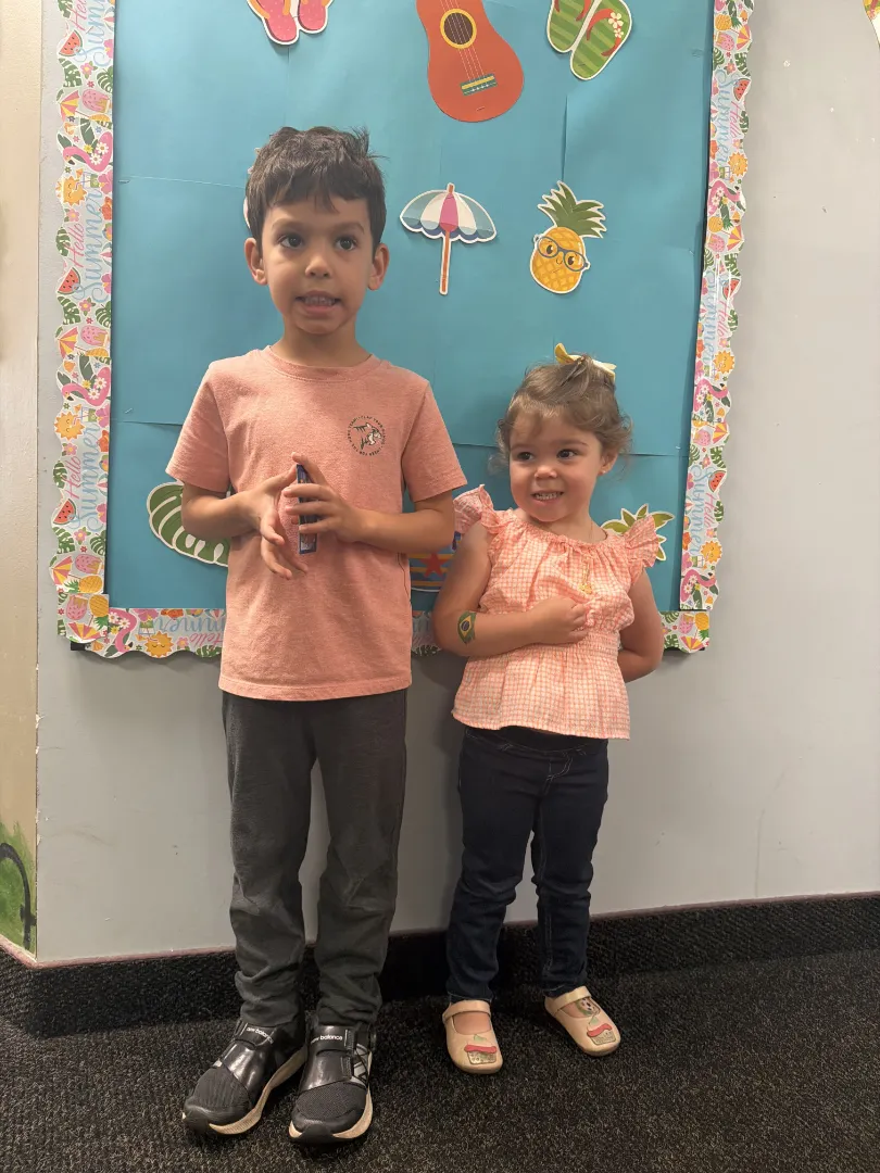 Two young Dental Care Kids patients by the activity wall