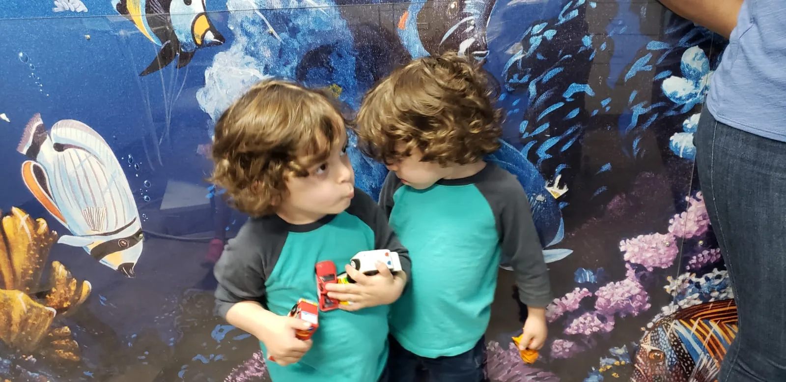 Two Dental Care Kids patients with their toys in the mural hallway