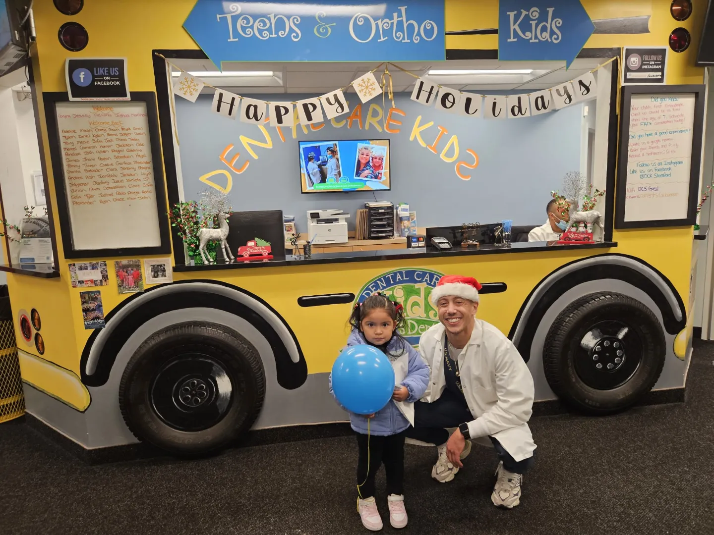 A young Dental Care Kids patient by the practice school bus with a balloon