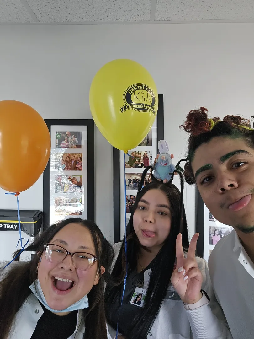 Dental Care Kids team members celebrating with a patient