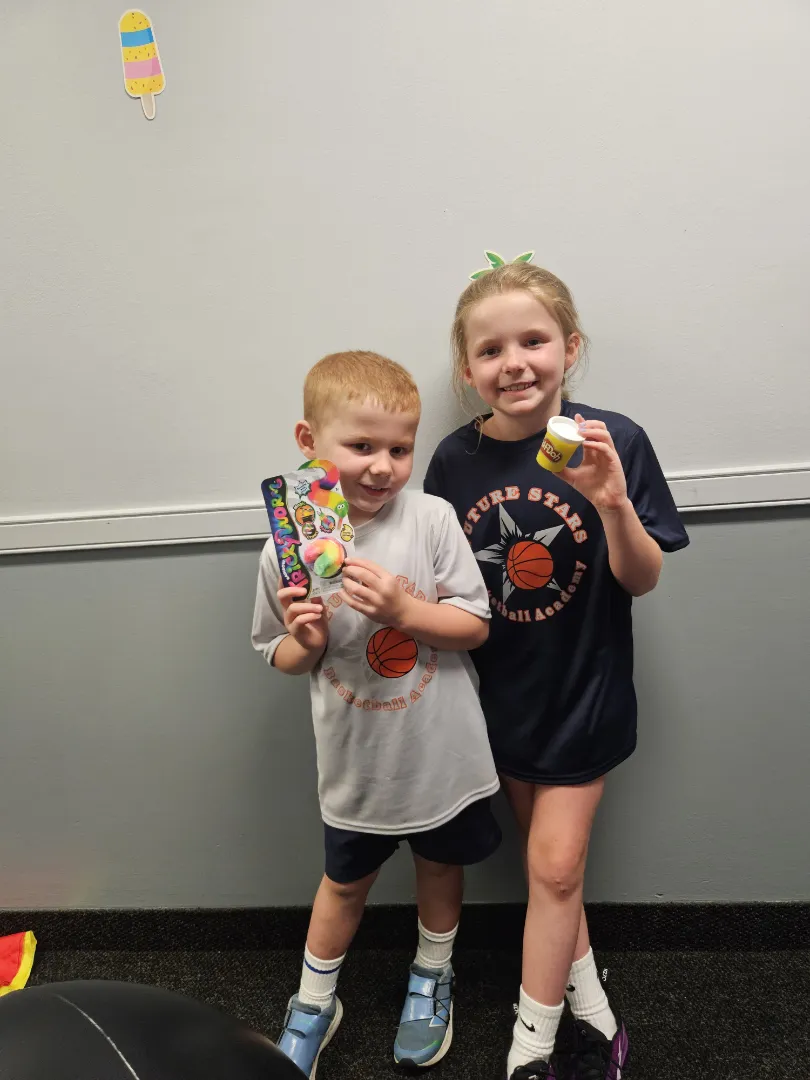 Two Dental Care Kids patients holding the toothbrushes they picked after a preventive visit