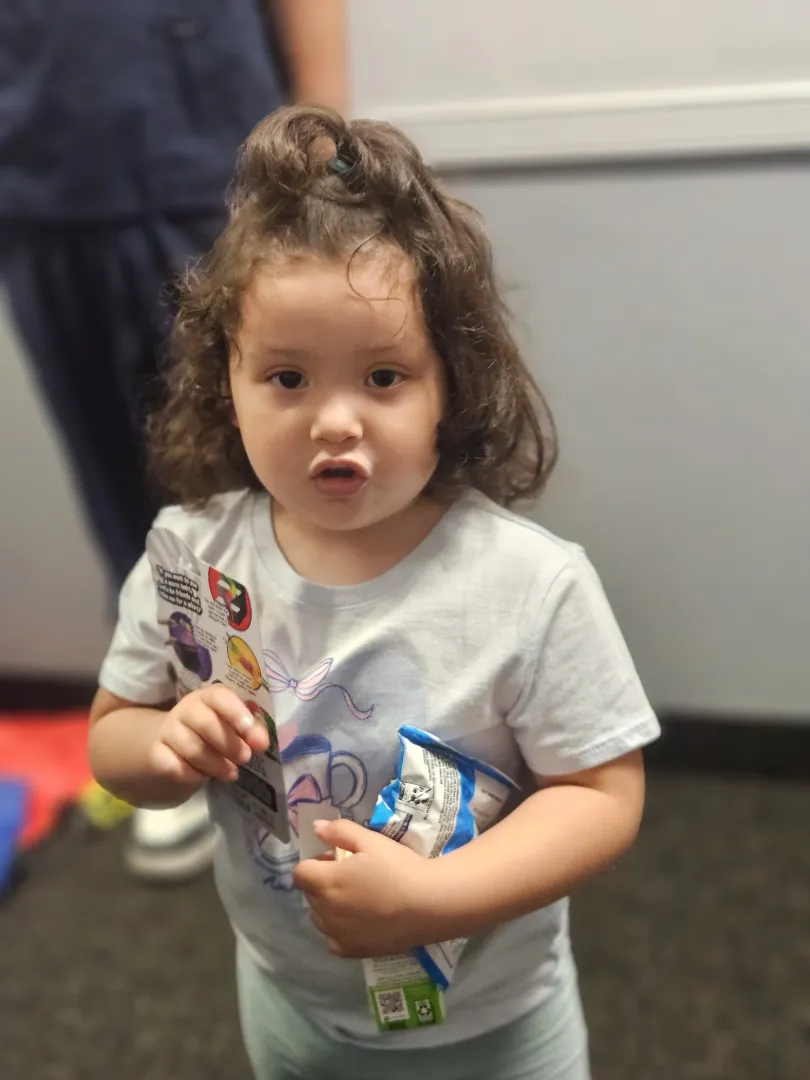 A young Dental Care Kids patient holding the prize she picked