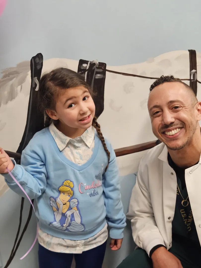 A Dental Care Kids patient smiling in the chair beside her dentist