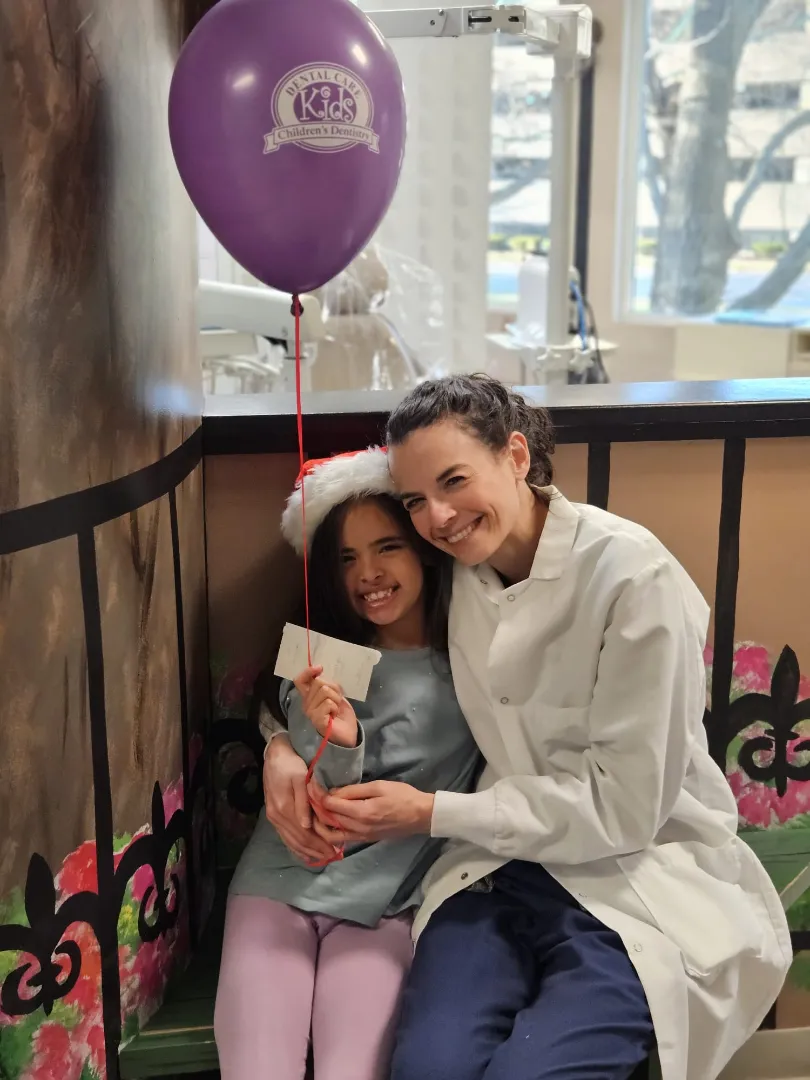 A Dental Care Kids patient hugging a team member after treatment