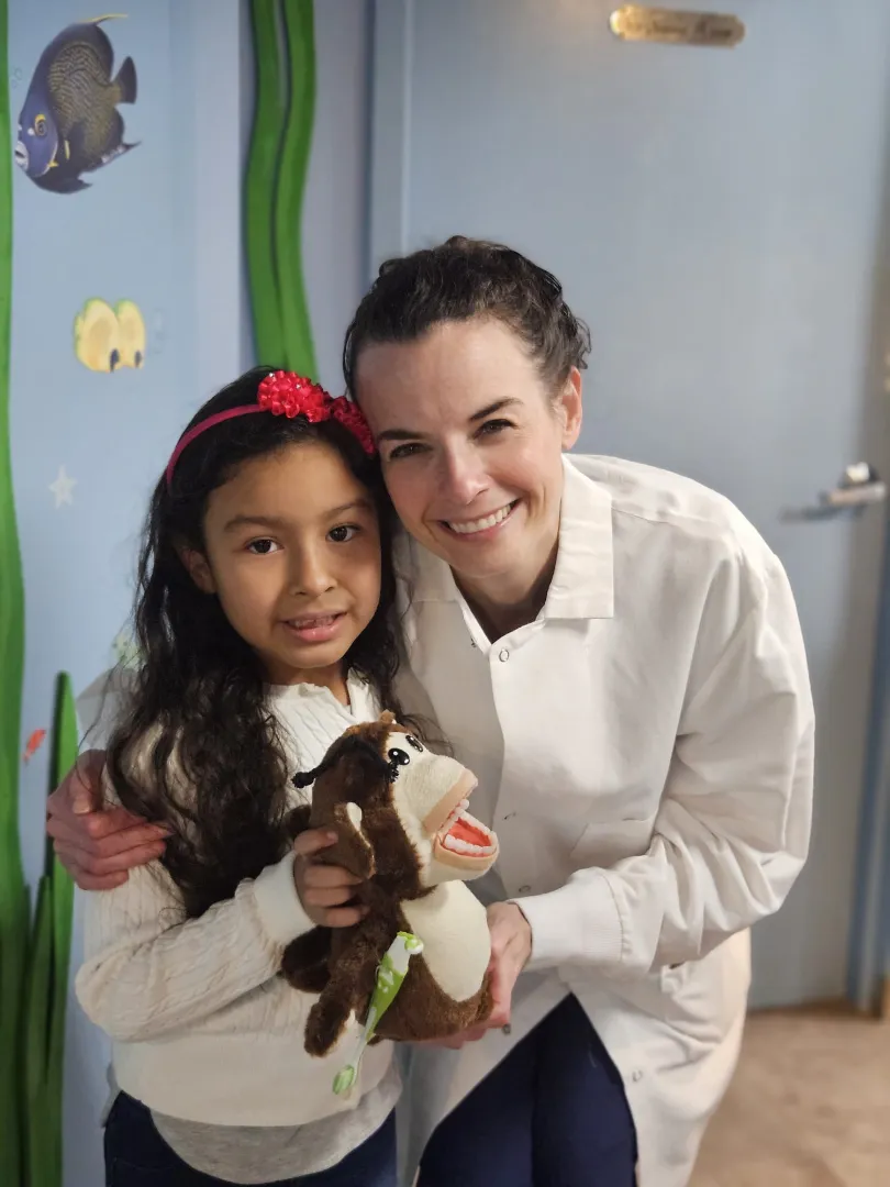 A Dental Care Kids hygienist and a young patient smiling together after a visit