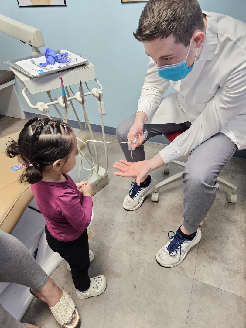 A Dental Care Kids team member working with a young patient in the chair