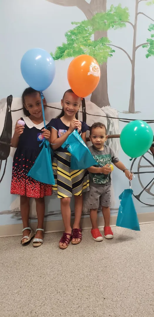 Dental Care Kids patients with a balloon and goodie bag after their visit