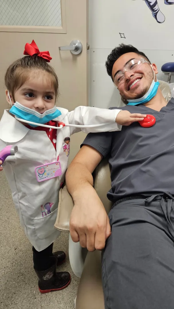 A young Dental Care Kids patient playing dentist with a team member during show-tell-do