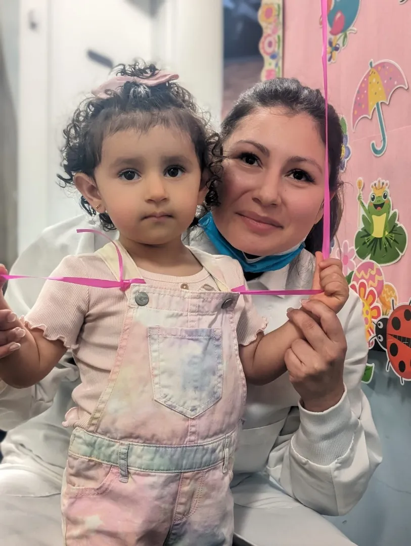 A Dental Care Kids team member with a toddler patient
