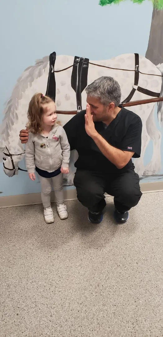 A Dental Care Kids team member with a toddler patient