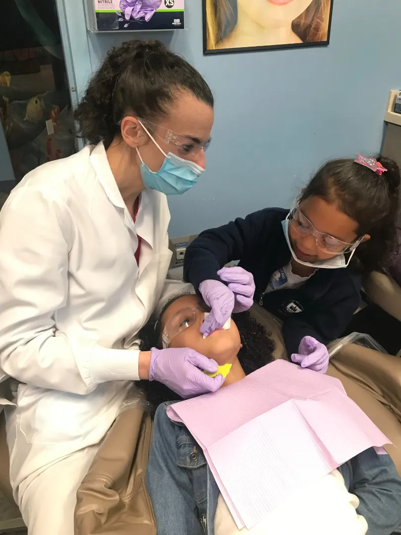 A Dental Care Kids dentist working with a young patient in the treatment room