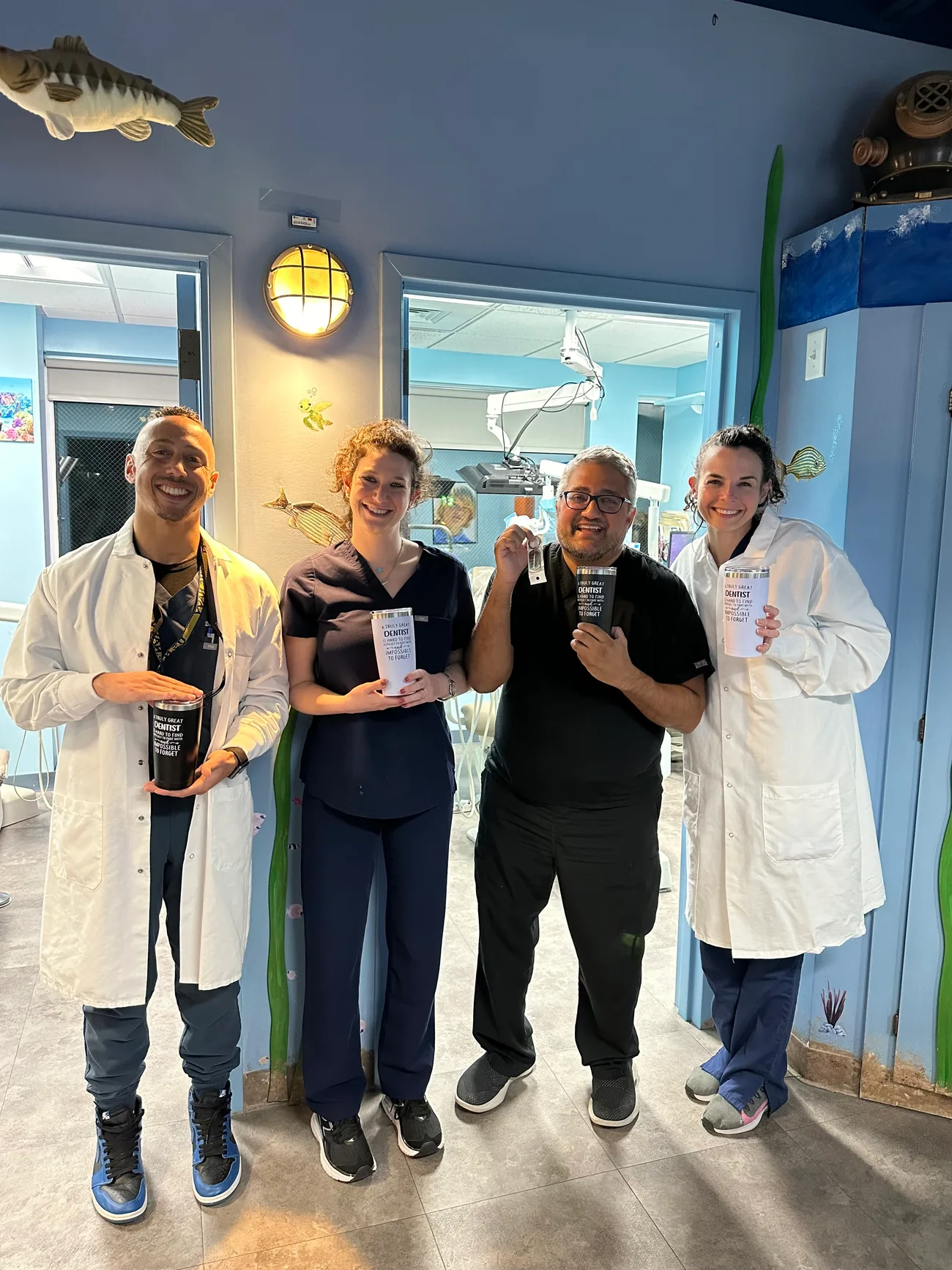 The Dental Care Kids pediatric team in the underwater-mural hallway